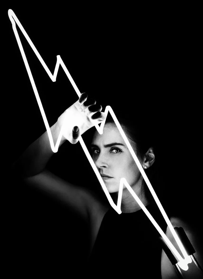 Neon artist Dani Bonnet holding a hand-bent white glass neon lightning bolt
