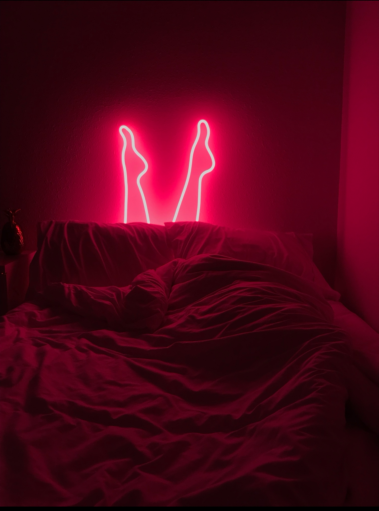 Glass Art Neon Pink Legs coming out of a bed and bed sheets