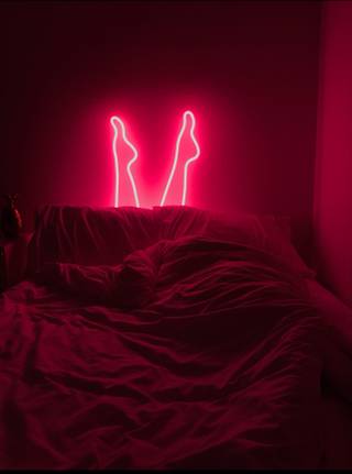 Glass Art Neon Pink Legs coming out of a bed and bed sheets