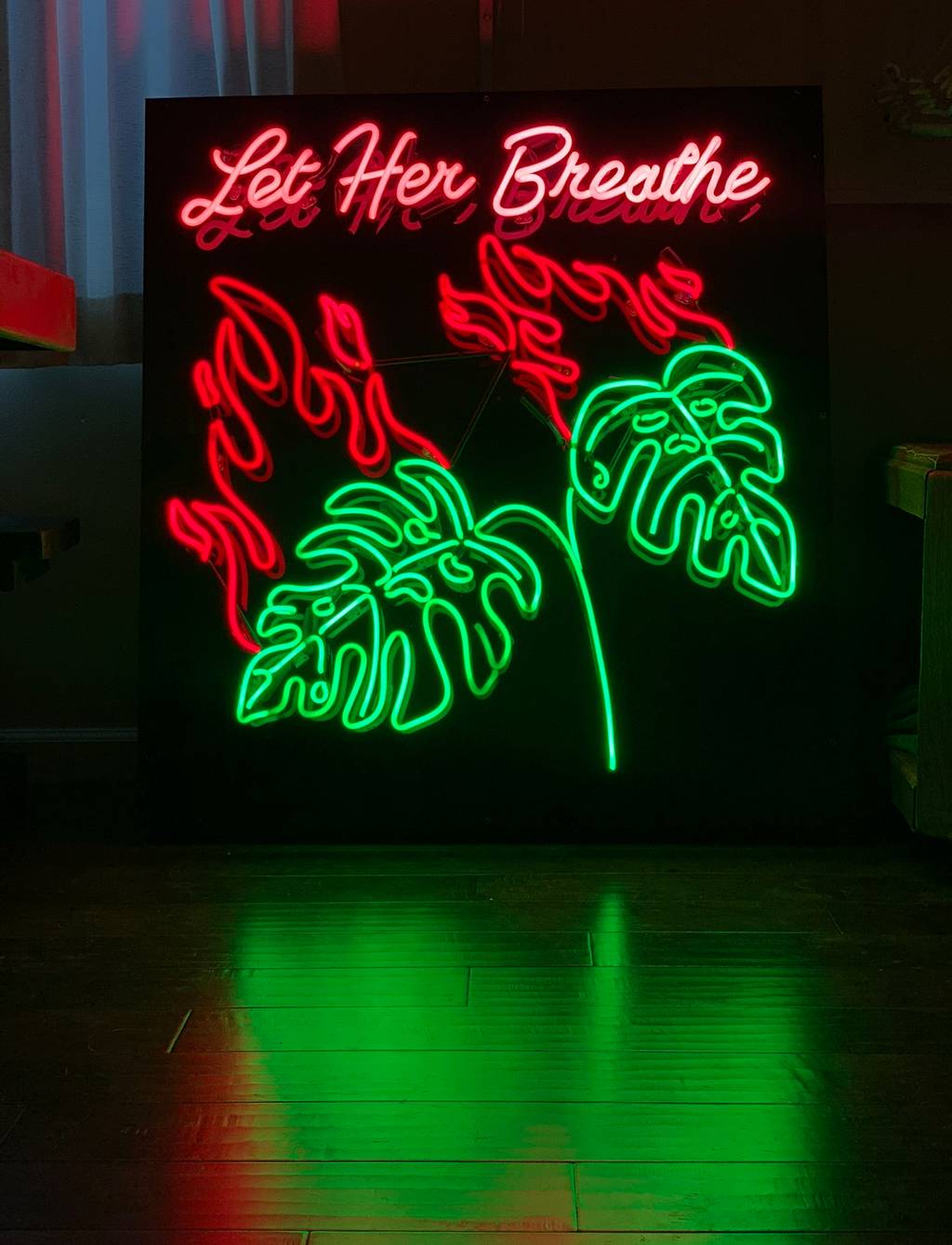 Let Her Breathe Neon Sign featuring monstera leaves flames and text. Made out of hand bent glass neon.