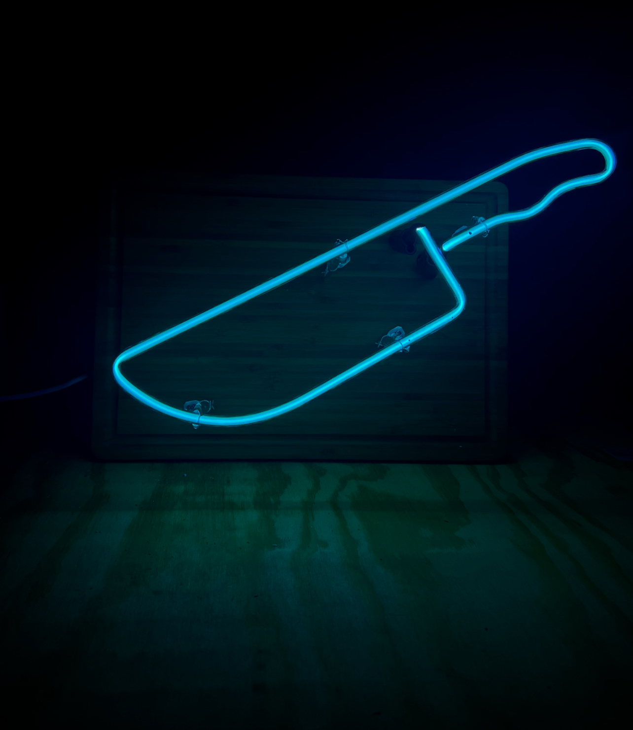 Neon Glass Chef’s Knife mounted to a wood cutting board